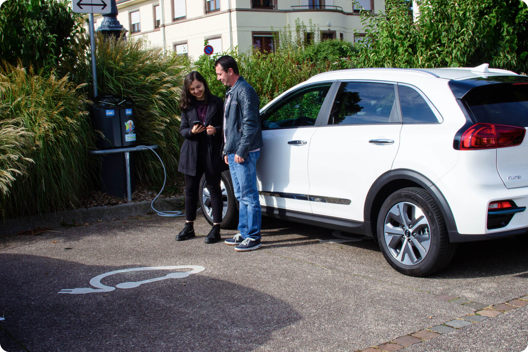 Un homme et une femme consultent l'application Chargemap pendant la recharge de leur voiture électrique